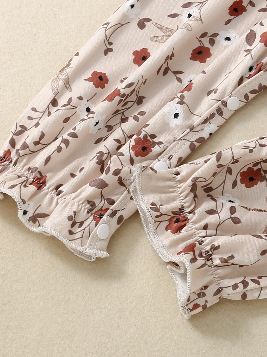 Baby jumpsuit with apricot floral print, smocked details, and ruffled cuffs.