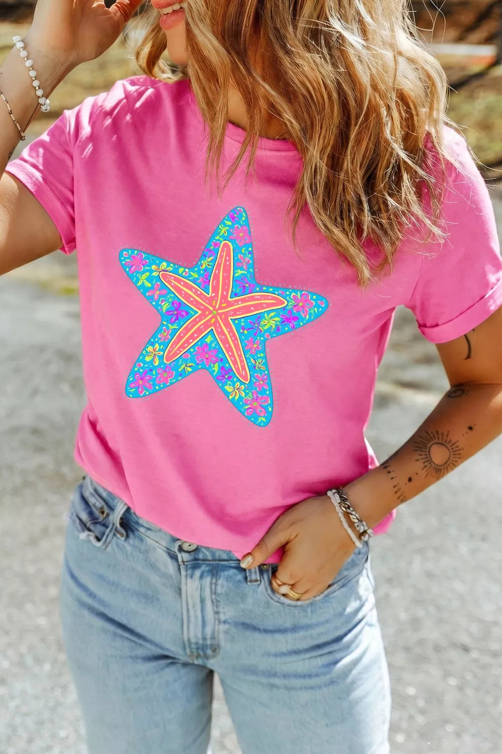Pink t-shirt with a colorful starfish graphic, short sleeves, crew neck.