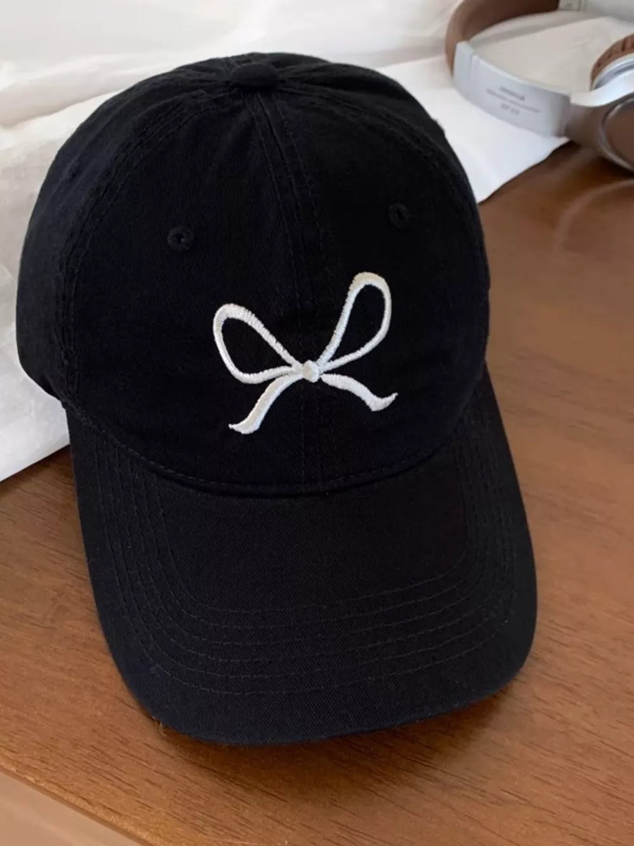 Black baseball cap with white embroidered bow detail