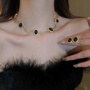 Gold oval gemstone necklace and matching earrings set with black stones
