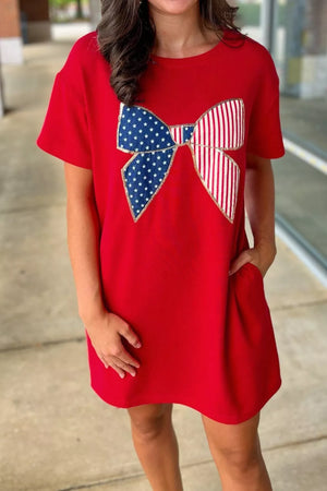 Red cotton mini dress with a stars and stripes bow applique and pockets.