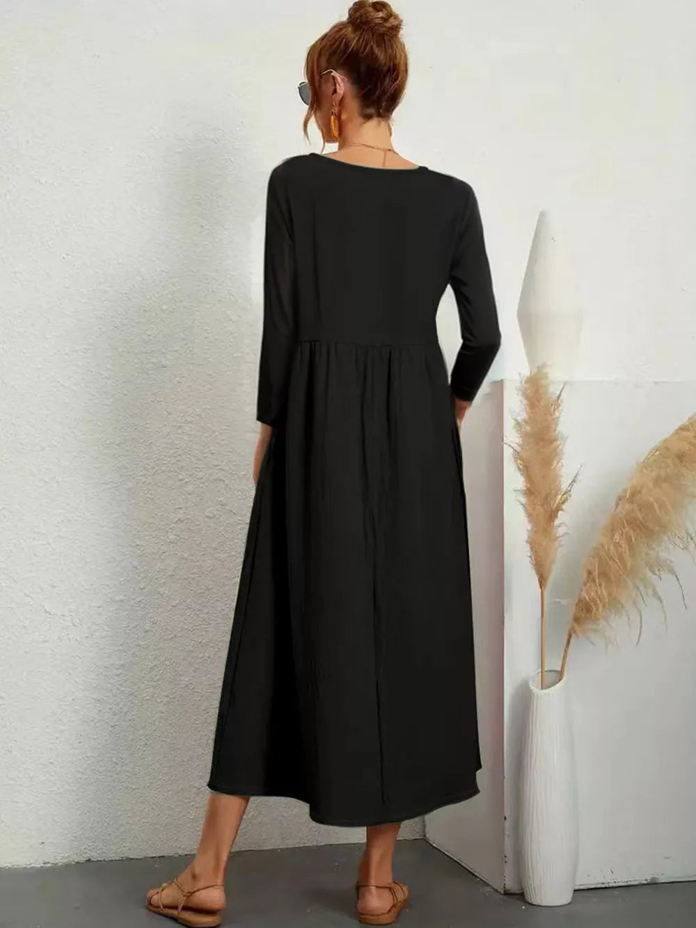 Black midi dress with V-neck, long sleeves, and pockets.