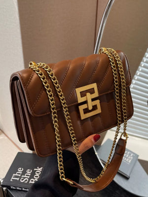 Chic quilted crossbody bag in brown with gold chain strap and gold hardware detail.