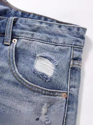 Ripped denim bermuda shorts in medium wash with distressed details and frayed edges.