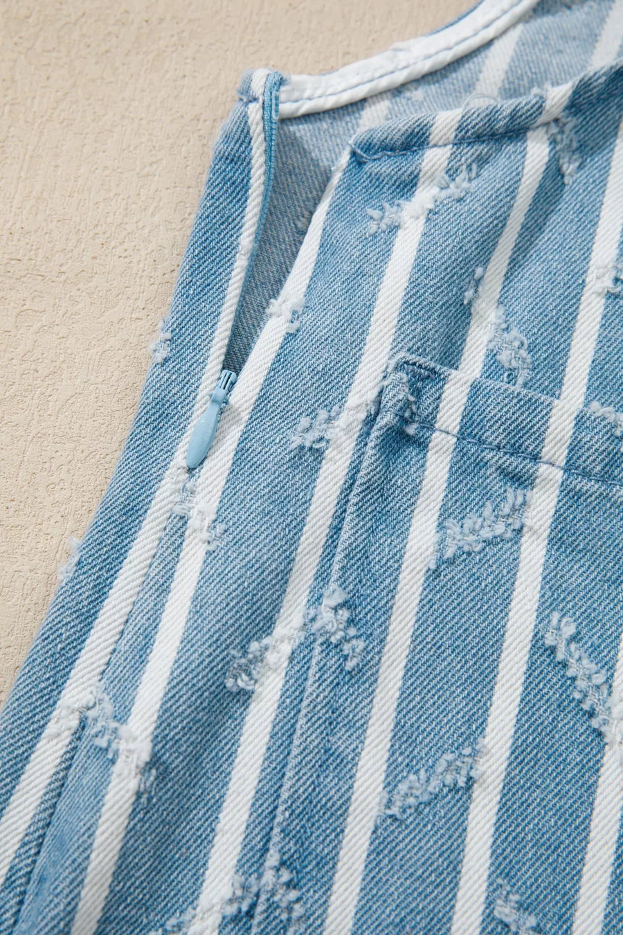 Striped distressed denim overalls with a side zipper detail.