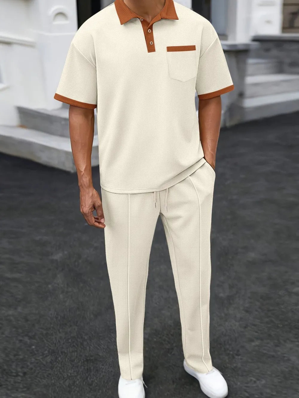 Beige textured polo shirt with contrast collar and pocket, paired with matching track pants.