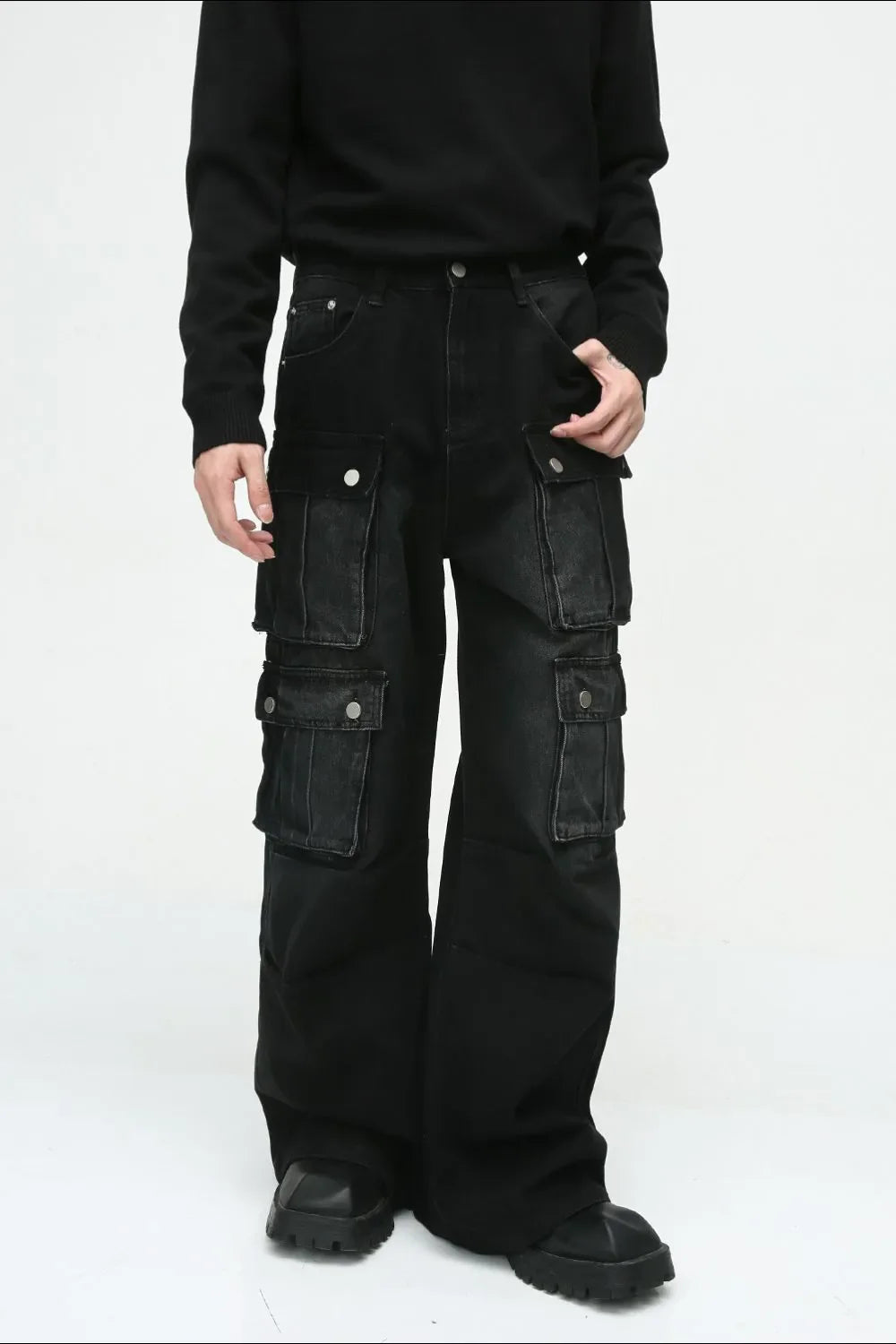 Dark denim wide-leg cargo pants with multiple utility pockets and silver button closures.