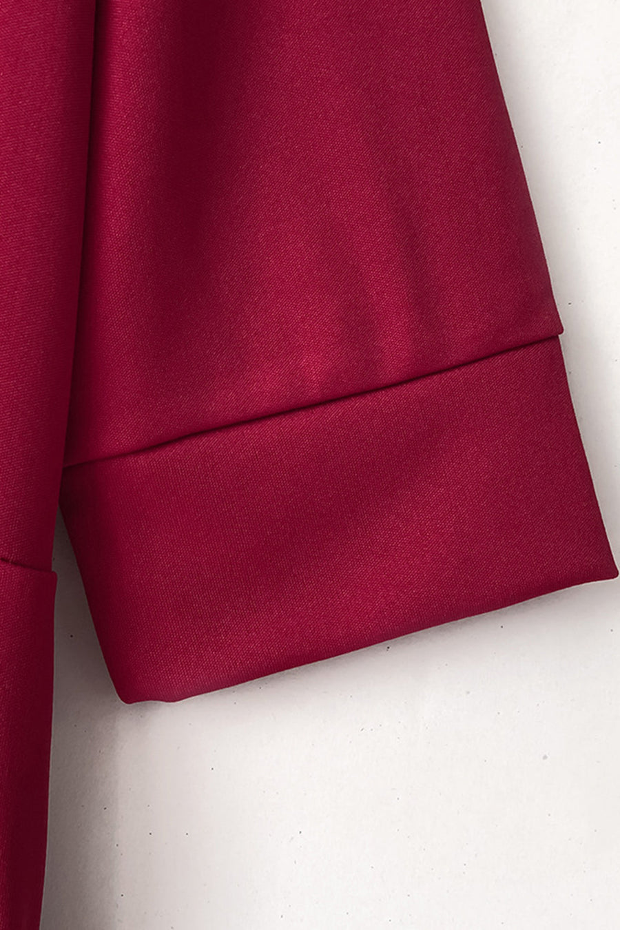Burgundy jumpsuit with cuffed sleeves and belt detail.