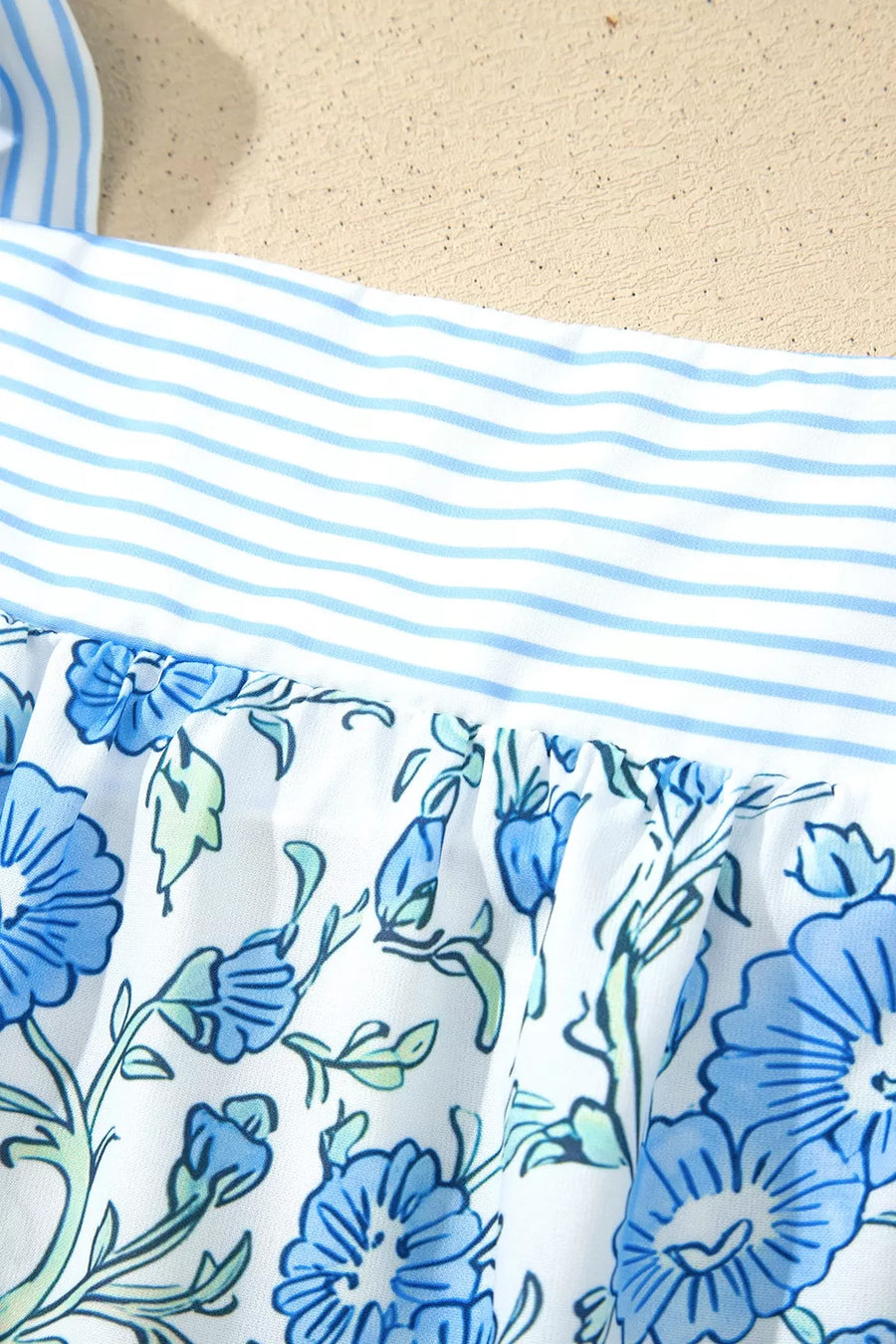 Floral print camisole top with blue stripes and adjustable tie straps.