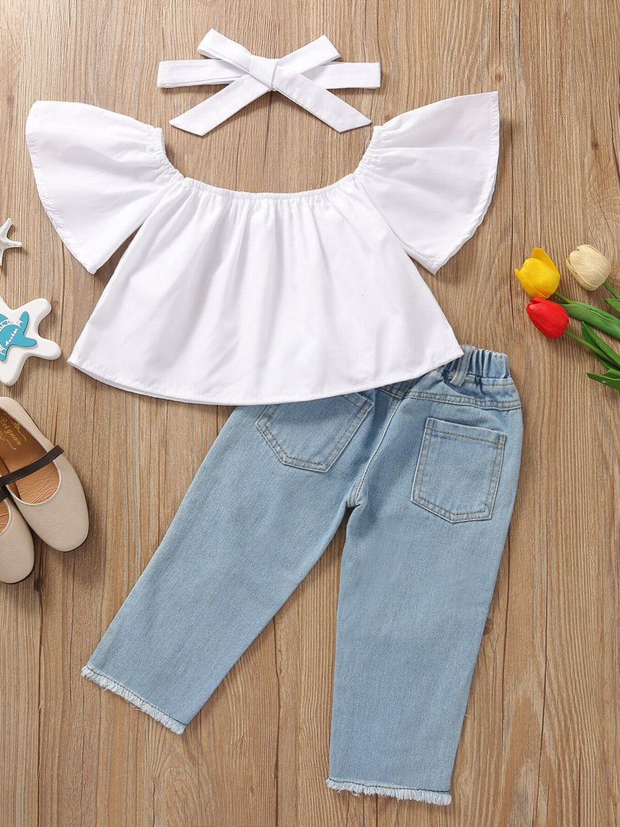 Toddler white off-shoulder ruffle top with distressed light wash jeans and headband.