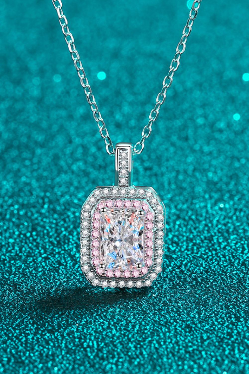 Silver necklace with radiant cut moissanite and pink halo.