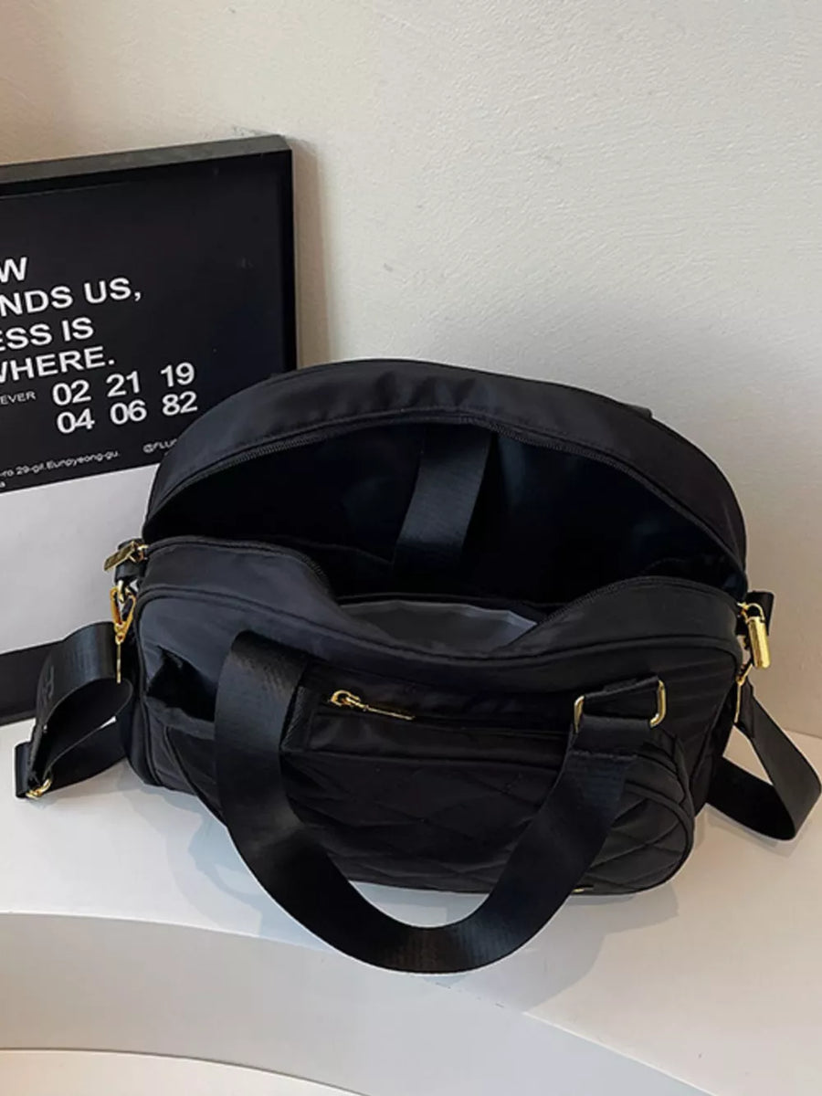 Black quilted Oxford bag with adjustable strap and gold hardware.