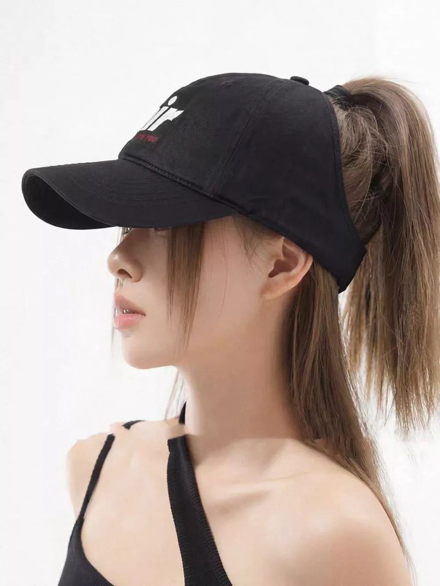 Black baseball cap with white embroidered letter detail and ponytail opening