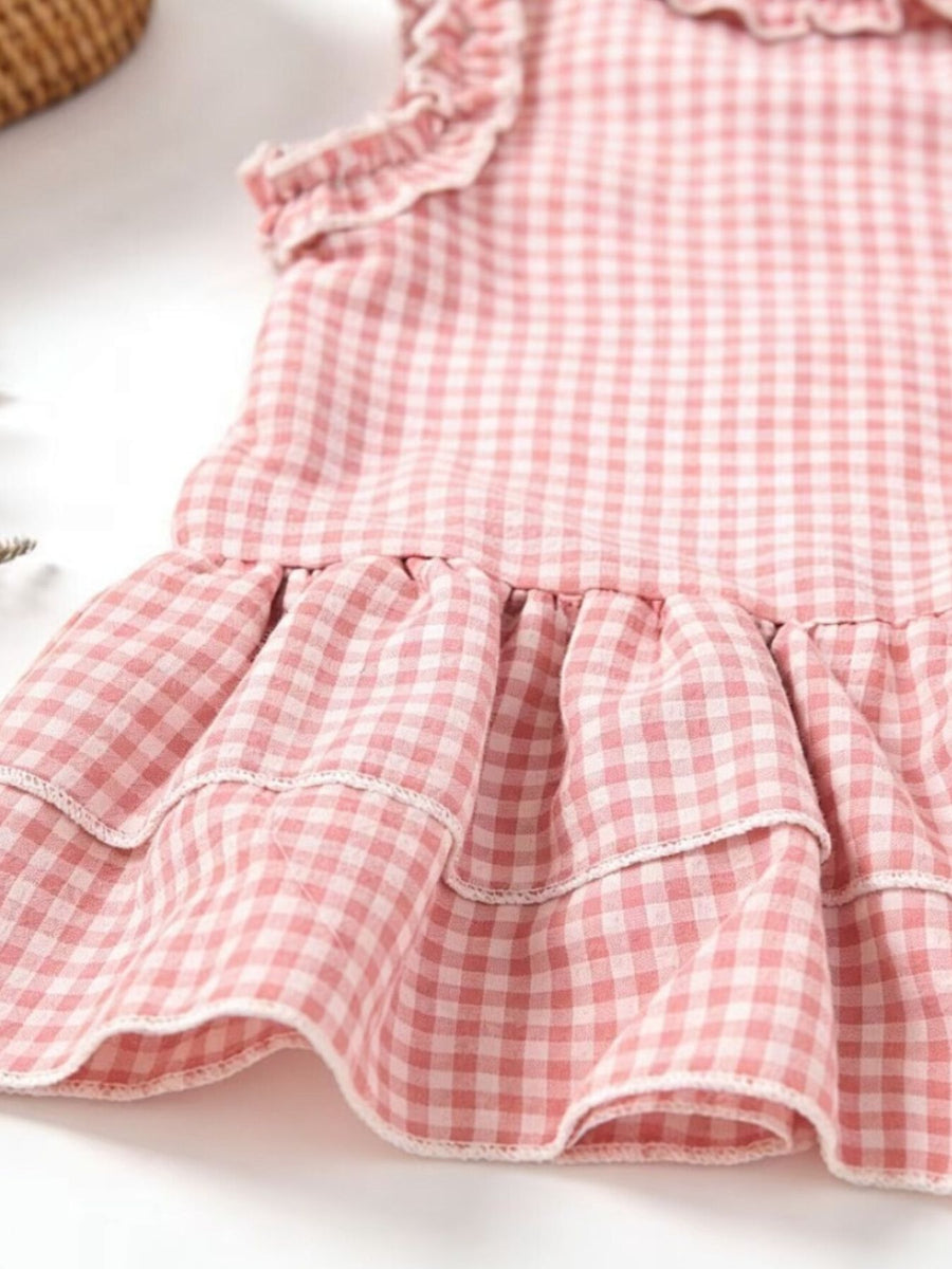 Blush pink gingham baby dress with ruffled tiers and neckline detail.