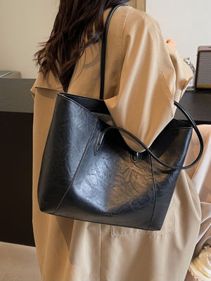 Black crinkled PU leather tote bag with top handles and a slouchy silhouette.
