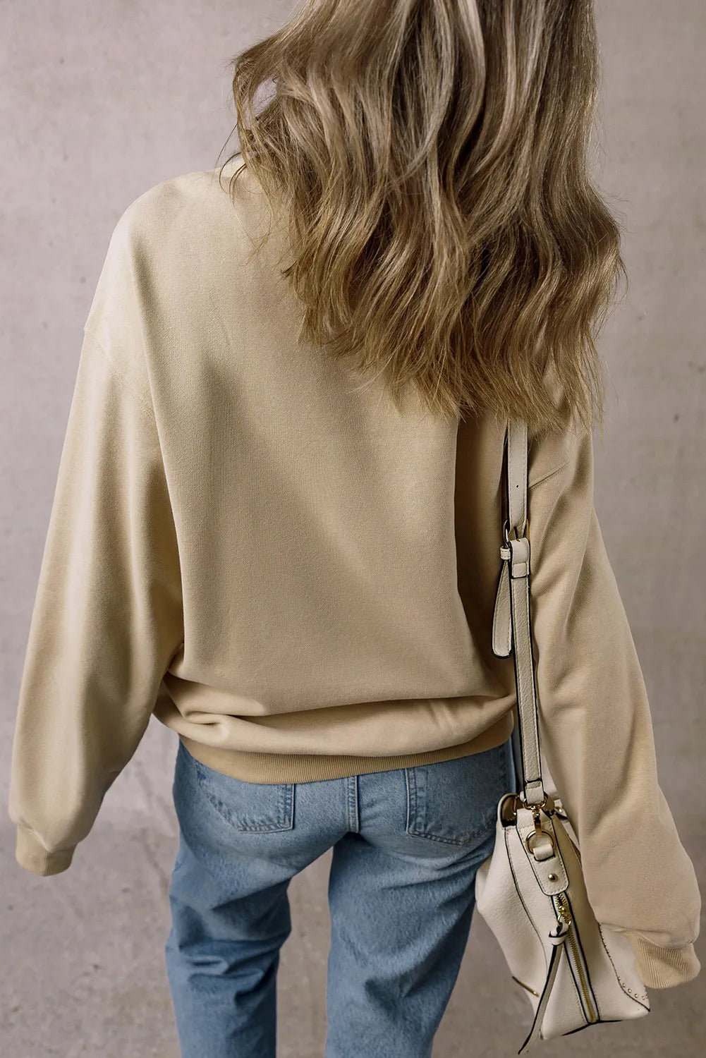 Khaki cotton crewneck sweatshirt with a relaxed fit, styled with jeans.