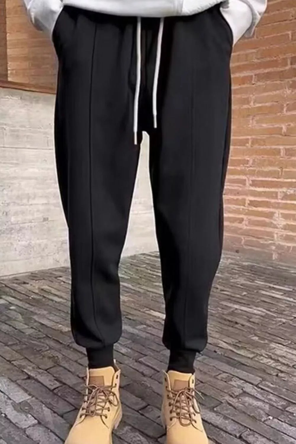 Men's black cotton sweatpants with white drawstring and cuffed ankles