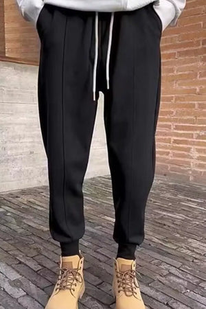 Men's black cotton sweatpants with white drawstring and cuffed ankles