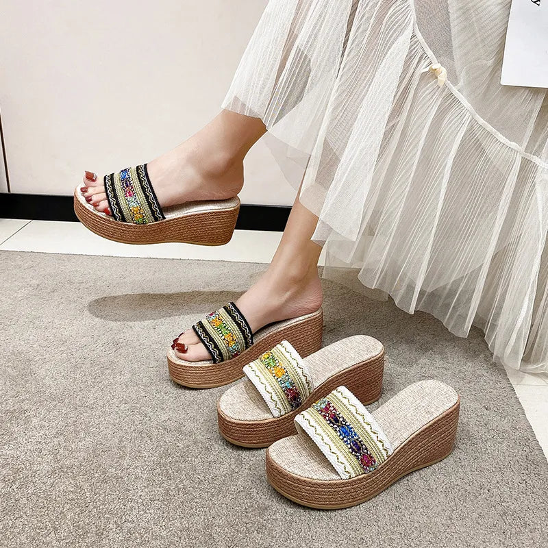 Embroidered platform wedge slides in beige with colorful floral detail and jute wedge.