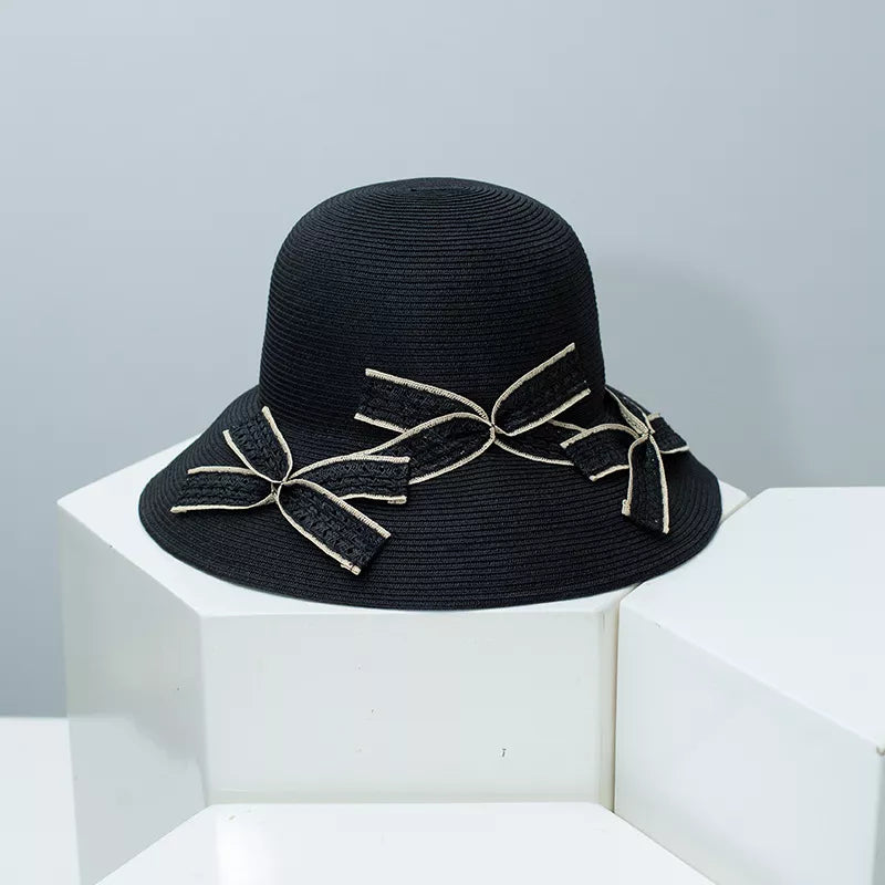 Black wheat straw sun hat with decorative bowknot accents.
