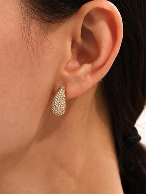 Gold teardrop stud earrings with pavé crystal details.