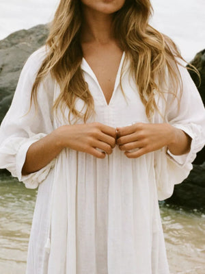 White tie-neck midi dress with puff sleeves and a V-neckline.