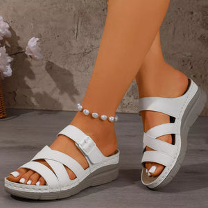 White multi-strap wedge sandals with adjustable buckle and criss-cross detail.