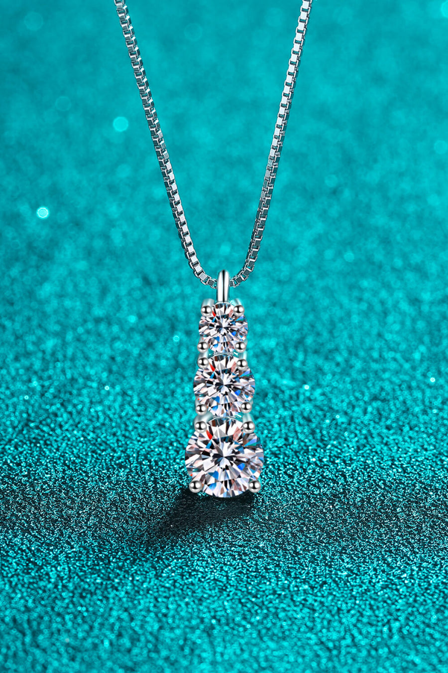 Silver moissanite cascade pendant with three round-cut stones on a sterling silver box chain.