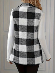 Textured black and white buffalo check vest jacket with collar and buttoned front, worn over a white long-sleeve shirt.