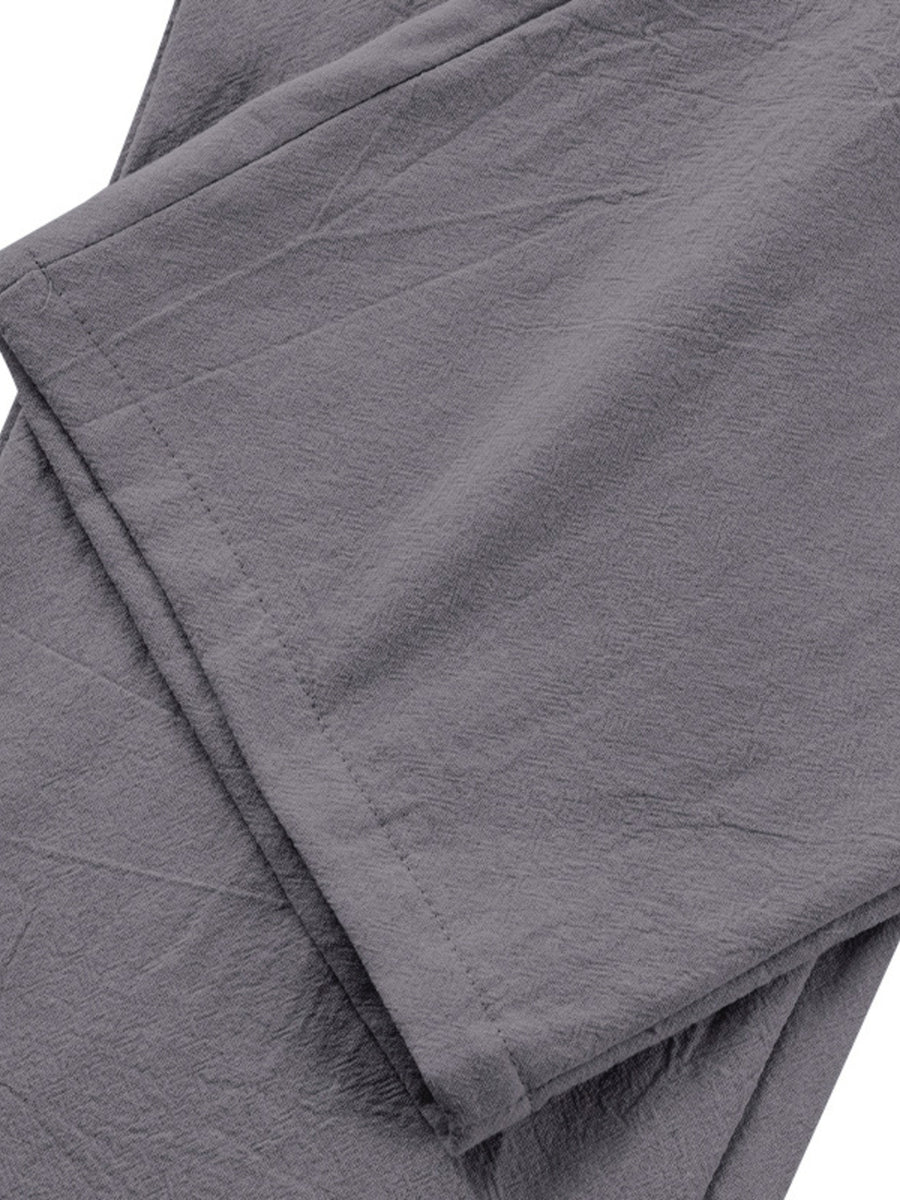 Grey relaxed fit sweatpants with pleated detail and textured fabric.