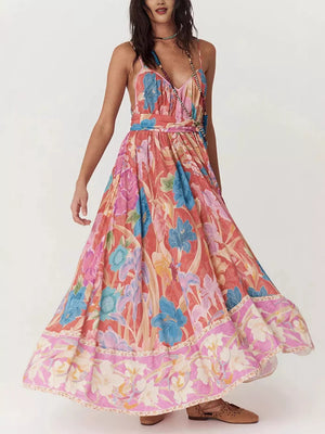 Maxi dress with spaghetti straps and a vibrant floral print in coral, blue, and pink.