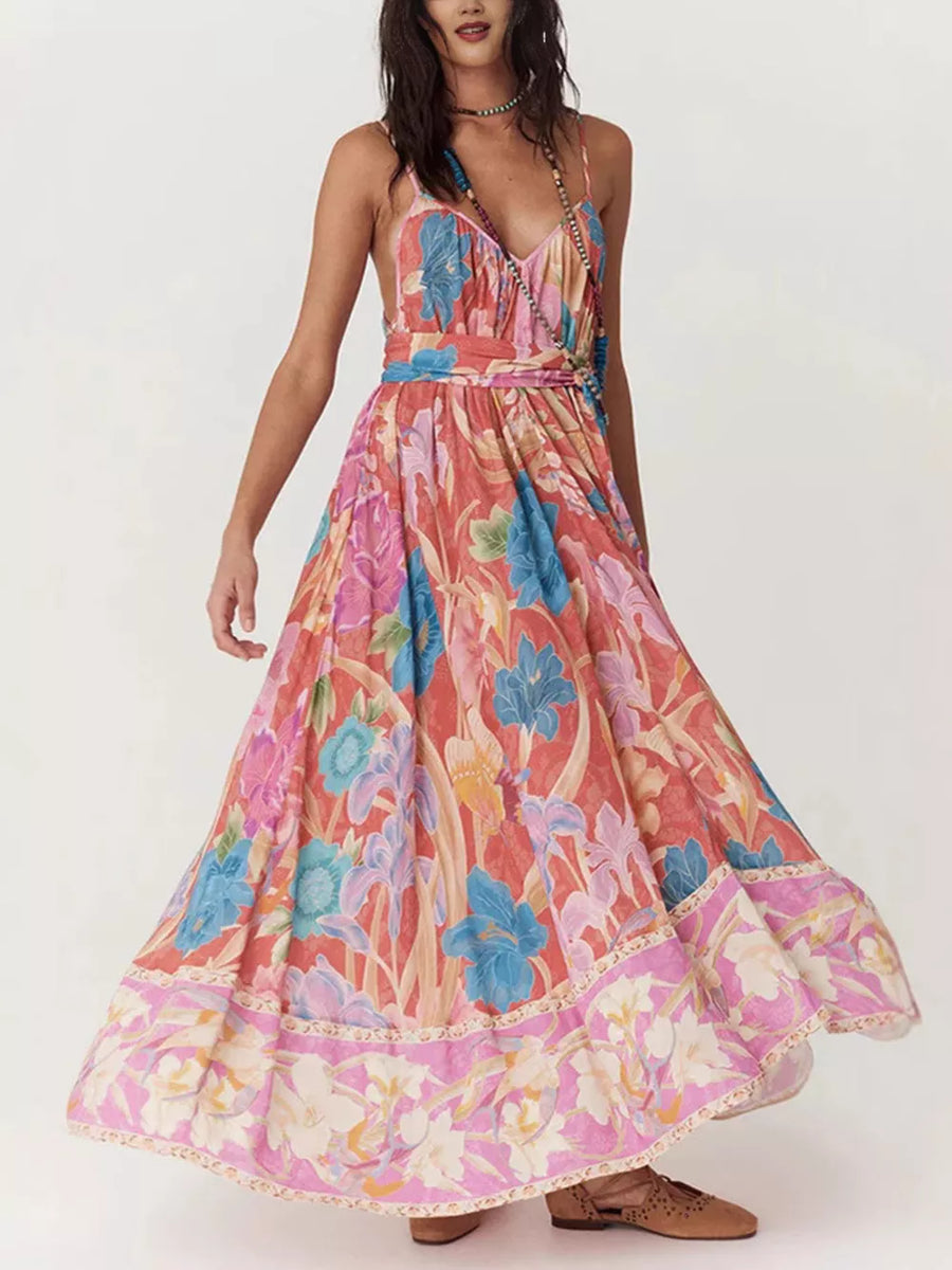 Maxi dress with spaghetti straps and a vibrant floral print in coral, blue, and pink.