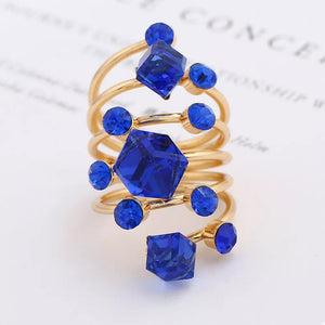 Gold-plated ring with royal blue crystals in geometric shapes and round accents.