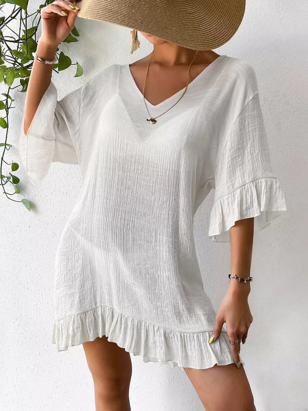 White ruffled V-neck cover-up dress with bell sleeves and textured fabric.