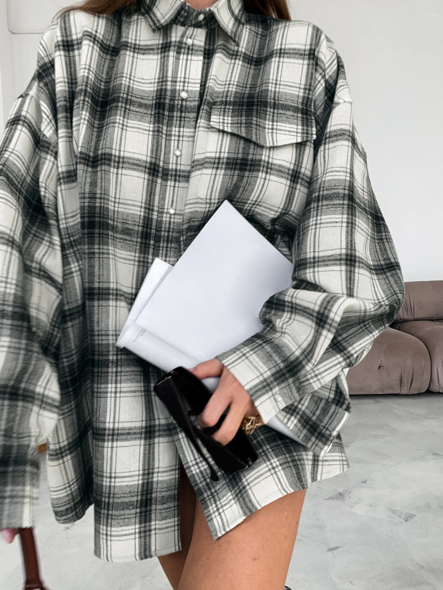 Button-up long sleeve cotton shirt in black and white plaid with a collar and chest pockets.