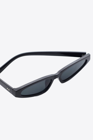 Black angular cat-eye sunglasses with dark lenses and gold stud details.