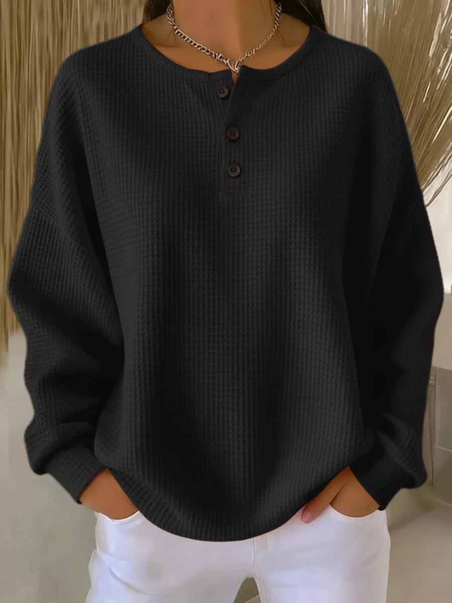 Black waffle knit button detail top with crew neck and long sleeves.