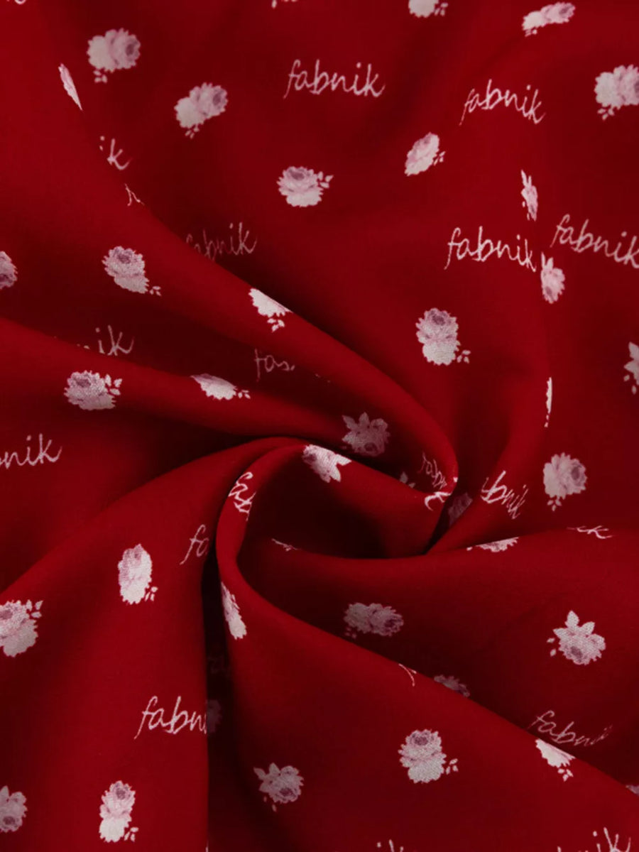 Red fabric with white floral print and "fabnik" text pattern
