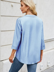 Light blue denim henley blouse with 3/4 sleeves and curved hem.