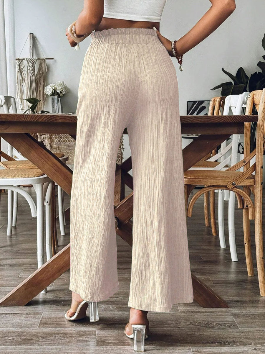 Textured wide-leg palazzo trousers in a light neutral color with a crinkled fabric finish.