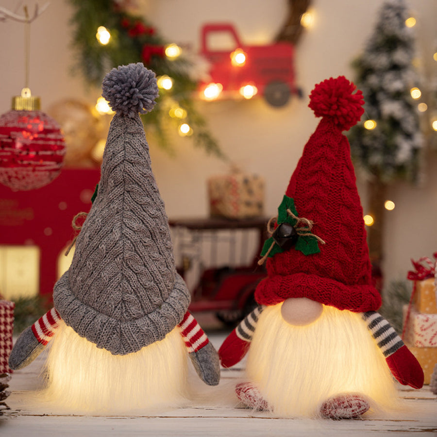 Illuminated knit gnomes in deep red and light gray with pompom hats and striped arms.
