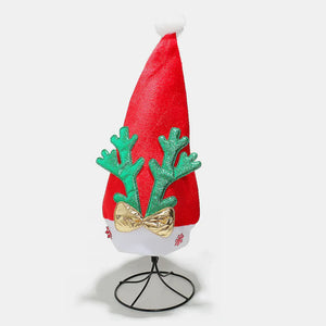 Red festive party hat with green glitter antlers and gold bow, topped with white pompom.