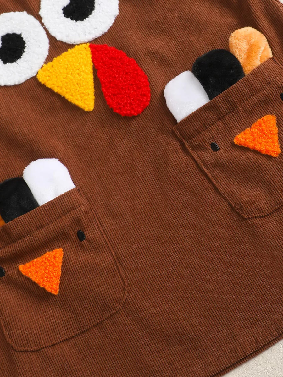 Brown corduroy baby dress with turkey applique, eyes, beak, and feather details.