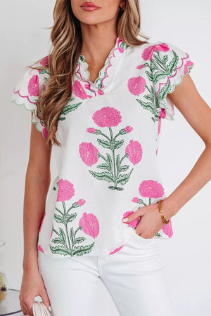 White cotton blouse with vibrant pink floral print and scalloped trim sleeves and neckline.
