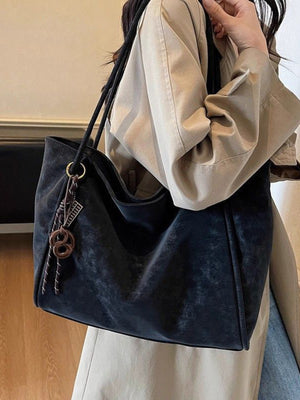 Large black suede shoulder bag with braided rope and charm detail