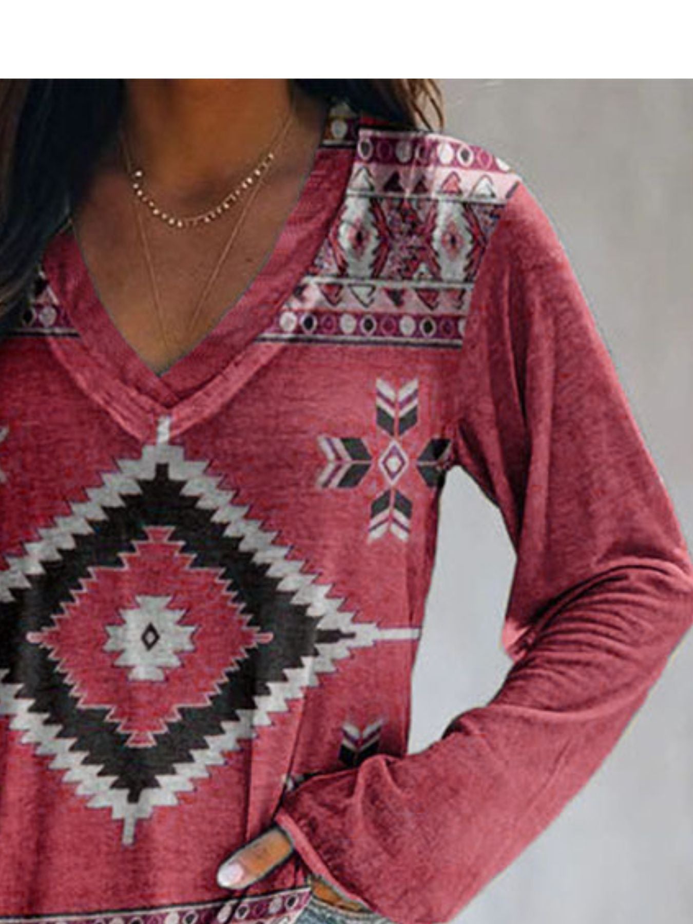 Red long sleeve v-neck t-shirt with geometric tribal print and banded neckline detail.