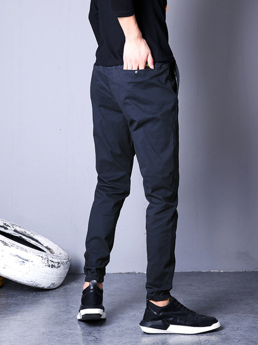 Men's navy blue jogger pants with elastic cuffs and drawstring waist.