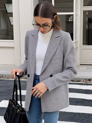 Houndstooth double-breasted blazer in black and white with buttoned closure.