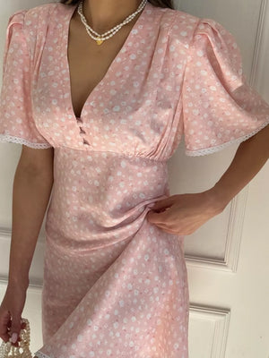 Pink floral print satin dress with V-neck, puff sleeves, and lace trim.