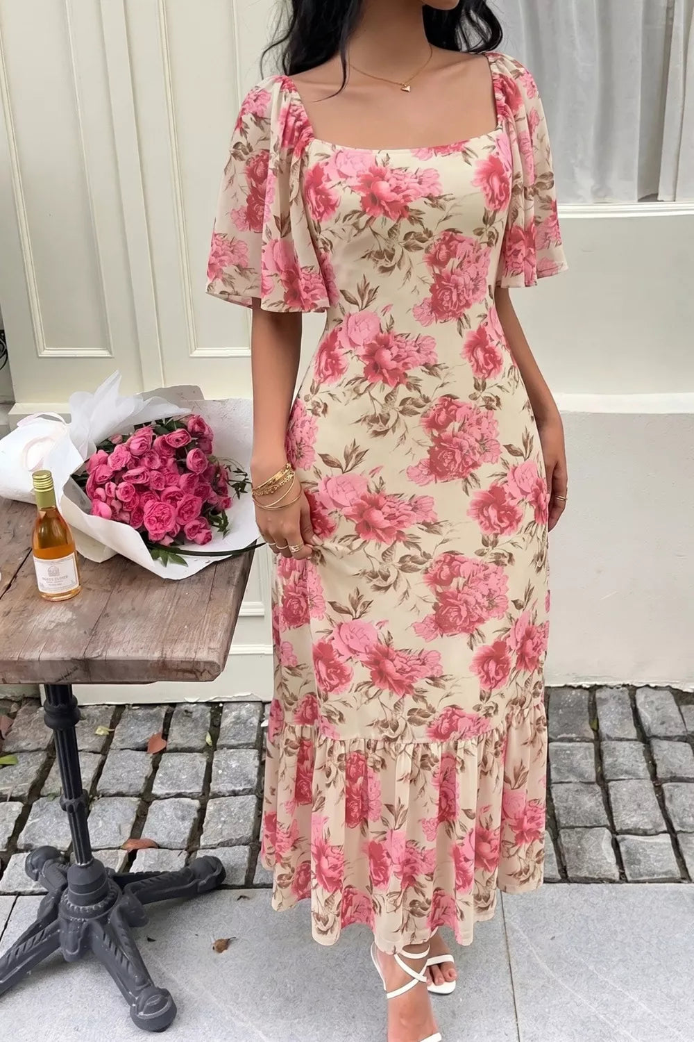 Charming floral midi dress with flutter sleeves, square neckline, and ruffled hem.